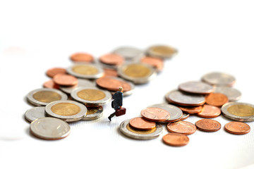 Miniature People : businessman walking between stack of coins