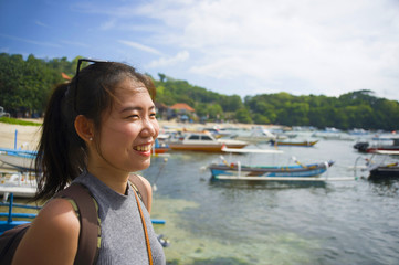  happy Asian Chinese woman with backpack in beach trip tourist excursion smiling sweet in Summer holiday and vacation travel