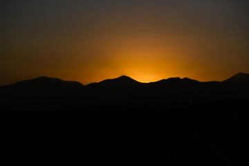 Sunset sun on Lanzarote, landscape of Canary Islands, sunset over volcanoes.
