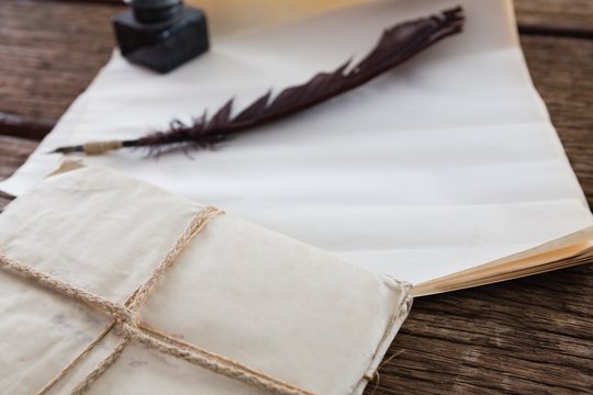 Quill feather, ink pot, and legal documents arranged on table - Powered by Adobe