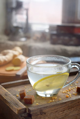 Cup of ginger tea with lemon and brown sugar on wooden backgraund. Hot drink for cough remedy. Traditional medicine and natural health care concept. Copy space for text