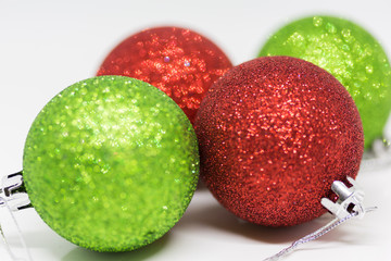 Green and Red Christmas baubles on a white background