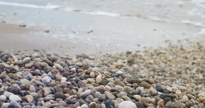 Foam surf on a pebble beach background