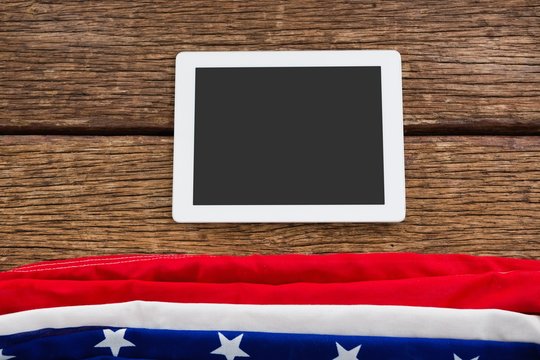 American flag and digital tablet arranged on wooden table