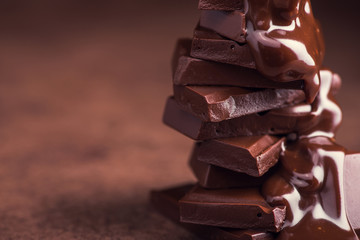 melted chocolate pouring into a piece of chocolate bars - 184413155