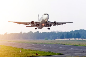 Fototapeta na wymiar Passenger airplane take off at sun on a runway.