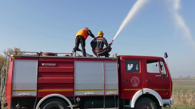 Firefighters Fire With Water Cannon ; Two firefighters extinguished the fire with water cannon from a fire truck