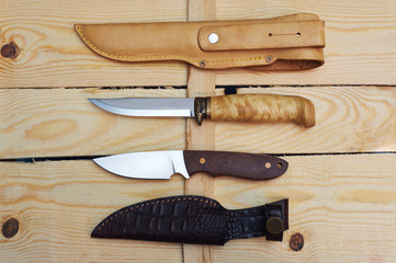 set of hunting knives on wooden background