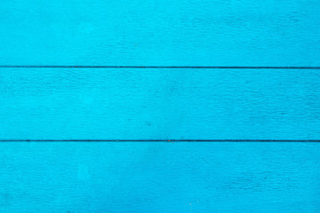 The bright blue textured wooden background, top view.