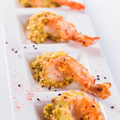 Fried shrimp in the sauce in a white plate on a light  background close up