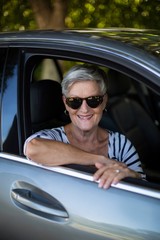 Smiling senior woman sitting in car
