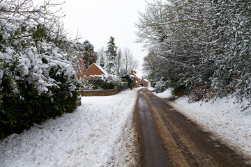 Snow covered road through a small village