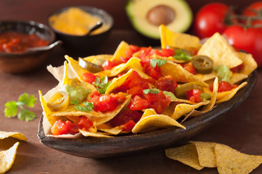 nachos loaded with salsa, guacamole, cheese and jalapeno