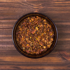 Tomato spice in a bowl on a wooden background