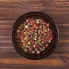 Peppers mix in a bowl on a wooden background