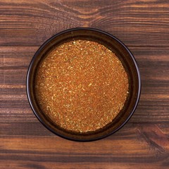 Spice mix - paprika, dried onion, white mustard, cumin, pepper in a bowl on a wooden background