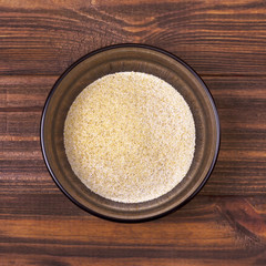 Garlic powder in a bowl on a wooden background