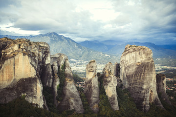 Landscape of monasteries of Meteora in Greece in Thessaly at the early morning. Cliffs of Meteora opposite a morning cloudy sky background