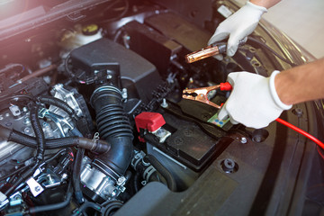 Mechanic using jumper cables to start a car
