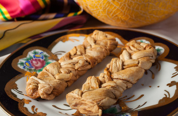 Dried melon-braid at the dish.Uzbek dessert.Selective focus.