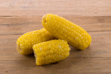 closeup corn on cobs on rustic wooden table