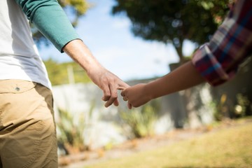 Cropped image of father and son holding hands