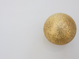 shiny Christmas ball gold color on a white background, top view