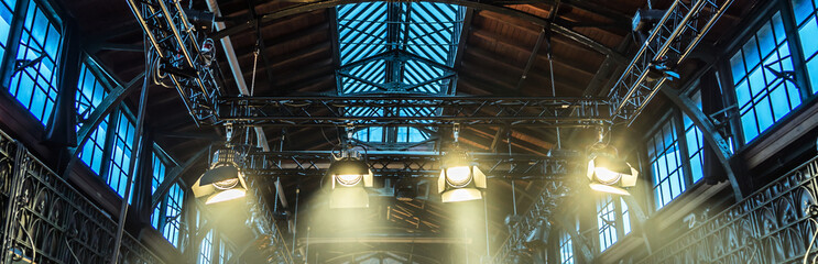 Spotlight on the ceiling of a former factory hall for lighting during a concert