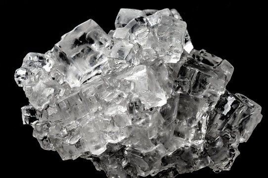 Cubic salt crystal aggregate against black background