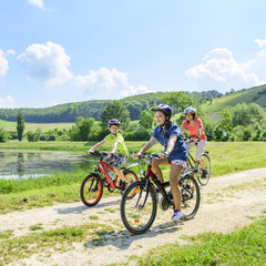 Mutter mit Kindern beim Radfahren am See