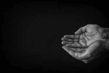 black and white image of open male hand begging for help.