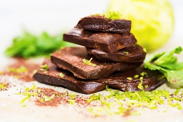 Pieces of wet chocolate,lime bark,mint leaf, cocoa powder,lime.