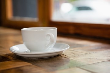 Close up of cup and saucer on wooden table