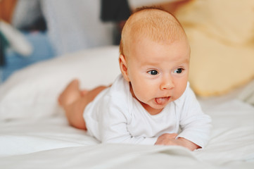 Portrait of adorable 3 month old baby boy lying on the tummy