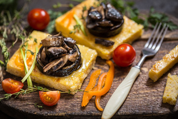 corn polenta with roasted mushrooms and eggplant, traditional Italian food with vegetables and thyme