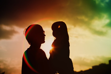 Father and little daughter silhouettes at sunset