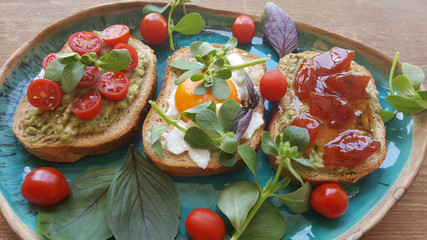 Vegan breakfast toasts with avocado cherry tomato, egg, and jam