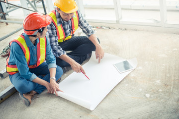 Engineer or Architect working at Construction Site with blueprint