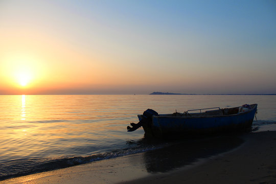 Colorful sunset at Durres, Albania, fishing boat on the beach © Marko