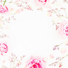 Pink roses and petals on white background. Floral frame of flowers. Flat lay, top view.