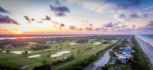 An aerial view looking over a golf course at sunset