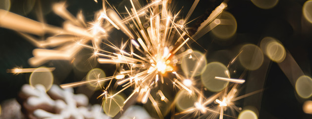 Obraz premium Close view of marshmallow in red cup with sparkler. soft selective focus. abstract bokeh background, copy space. Christmas or New Year composition.
