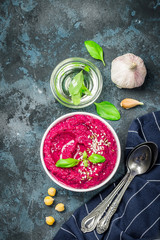 Vegan beet hummus on dark blue background. Top view, space for text.