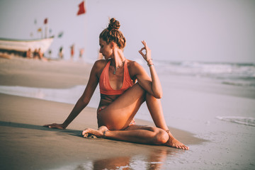 young woman in swimsuit practicing yoga on beach at goa - obrazy, fototapety, plakaty