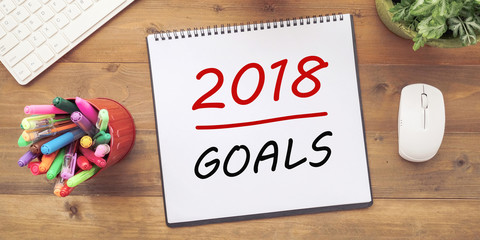 2018 goals on notebook  paper at office desk background, banner, sign business new year,  aim to success in business