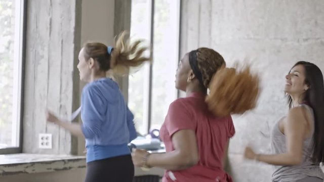 Tracking of happy multiethnic group of women dancing zumba and laughing