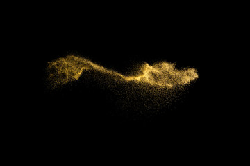 Yellow sand explosion isolated on black background. Abstract sand cloud. Yellow sand splash agianst...