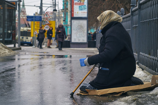 Old female beggar asking for money on Moscow street in winter