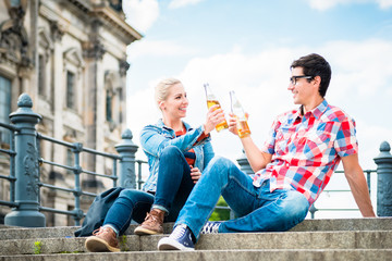 tourists, woman and man, enjoying the view from bridge at the Museum Island in Berlin with beer