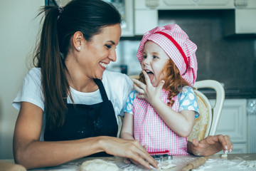 Happy girl licking fingers and looking at mother